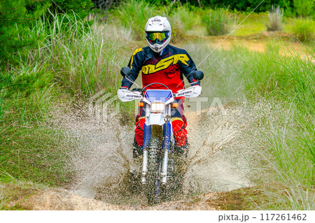 水溜まりを駆け抜け爆走する、二輪車（バイク オフローダー） 117261462