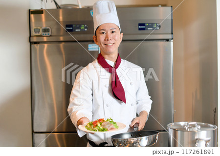 料理を提供する若いアジア人の男性調理師 料理を提供する若いアジア人の男性調理師 117261891