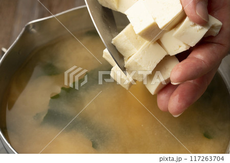 味噌汁を作る　豆腐切る　わかめを入れる 117263704