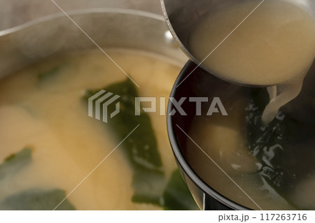 味噌汁 豆腐とわかめの味噌汁をお椀によそう 味噌汁 豆腐とわかめの味噌汁をお椀によそう 117263716