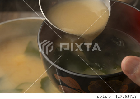 味噌汁 豆腐とわかめの味噌汁をお椀によそう 味噌汁 豆腐とわかめの味噌汁をお椀によそう 117263718