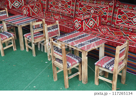 Traditional cafe features patterned upholstery and wooden furniture for a cozy atmosphere Traditional cafe features patterned upholstery and wooden furniture for a cozy atmosphere 117265134