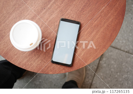 smart phone with empty screen and a coffee on table smart phone with empty screen and a coffee on table 117265135