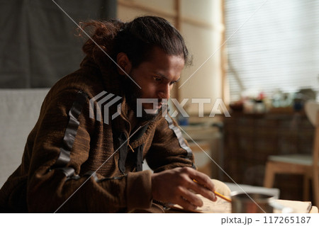 Man Concentrating on Building Project in Workshop 117265187