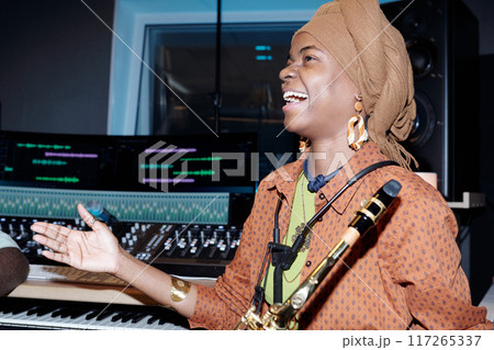 Laughing Musician Holding Saxophone During Recording Session 117265337