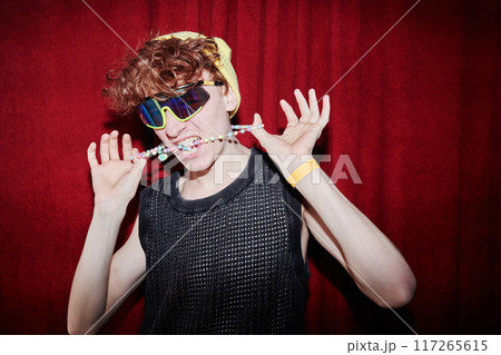 Guy with neck accessory between teeth Guy with neck accessory between teeth 117265615