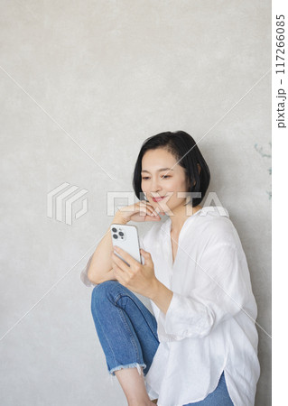 部屋でスマホを操作する戻る女性 部屋でスマホを操作する戻る女性 117266085