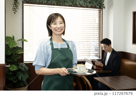 カメラ目線で微笑むカフェの女性スタッフ カメラ目線で微笑むカフェの女性スタッフ 117267679