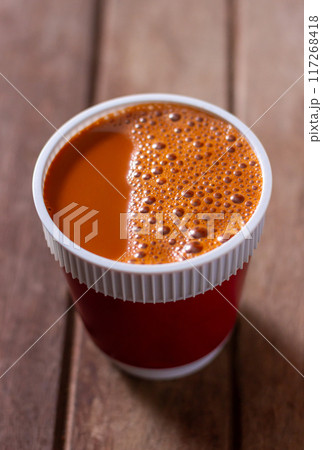 Hot milk tea in a white cup wooden table blurred background Hot milk tea in a white cup wooden table blurred background 117268418