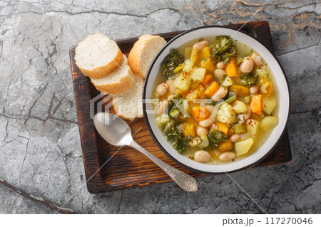 Autumn vegetarian Frantoiana soup with beans, potatoes, pumpkin, kale, carrots, onions and celery close-up in a bowl. Horizontal top view 117270046