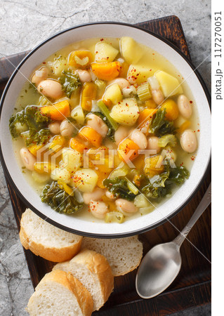 Zuppa Frantoiana italian bean soup with pumpkin and vegetables closeup on the bowl. Vertical top view 117270051