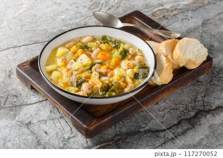 Autumn vegetarian Frantoiana soup with beans, potatoes, pumpkin, kale, carrots, onions and celery close-up in a bowl. Horizontal 117270052