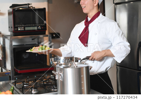 料理を提供する若いアジア人の男性調理師 117270434