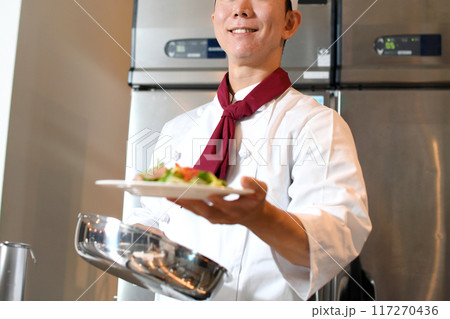 料理を提供する若いアジア人の男性調理師 117270436