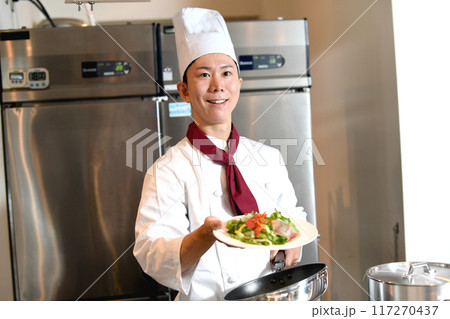 料理を提供する若いアジア人の男性調理師 117270437
