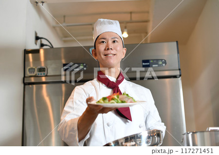 料理を提供する若いアジア人の男性調理師 料理を提供する若いアジア人の男性調理師 117271451