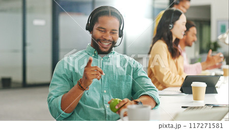 Call center, smile and a black man with an apple while working on a computer for sales or communication. Telemarketing, contact us and online support with a male employee as a consultant with fruit 117271581