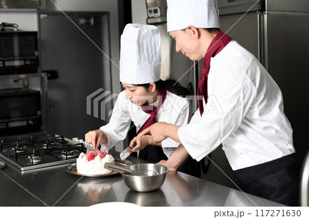 ケーキ作りする女性パティシエと教える男性 117271630