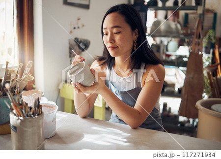 Pottery, art and sculpture with a japanese woman in a studio for design or a creative hobby as an artisan. Manufacturing, pattern or artist with a female potter sitting in her workshop as a sculptor Pottery, art and sculpture with a japanese woman in a studio for design or a creative hobby as an artisan. Manufacturing, pattern or artist with a female potter sitting in her workshop as a sculptor 117271934