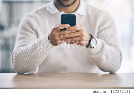 Phone, hands and social media with a man typing a text message while sitting at a table or desk. Mobile, communication and networking with a male sending an email or SMS on his wifi smartphone Phone, hands and social media with a man typing a text message while sitting at a table or desk. Mobile, communication and networking with a male sending an email or SMS on his wifi smartphone 117272181