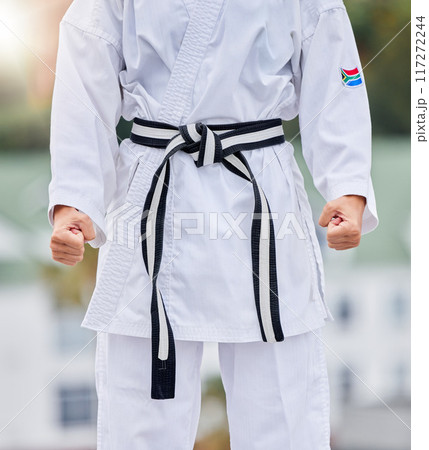 Karate, fitness and body of woman in martial arts training for competition with hands fist, fight and commitment in Japanese culture. Power, challenge and energy of sports person in taekwondo contest 117272244