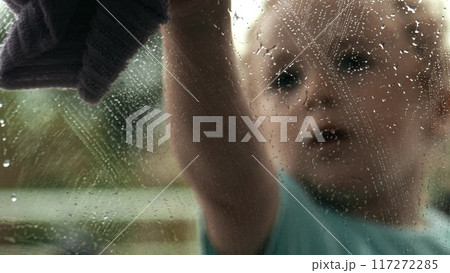 Little girl cleans window at home 117272285