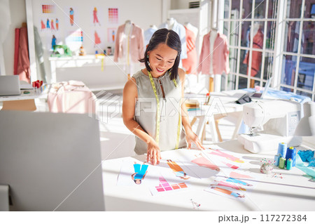 Fashion designer, drawing and asian woman, creative sketch of clothes and industrial tailor manufacturing in textile startup studio. Happy woman, artist and illustration, paper and color swatch ideas Fashion designer, drawing and asian woman, creative sketch of clothes and industrial tailor manufacturing in textile startup studio. Happy woman, artist and illustration, paper and color swatch ideas 117272384