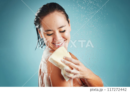 Studio, skincare and woman in shower with sponge isolated on a blue background mockup. Water splash, cleaning or healthy hygiene of female model bathing, washing or showering for beauty and body care 117272442