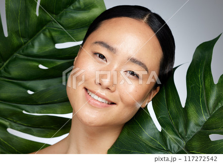 Face, beauty and asian woman with monstera leaf on gray studio background. A beautiful Japanese woman with healthy, glowing and flawless skin, skincare routine and makeup with organic plant cosmetics Face, beauty and asian woman with monstera leaf on gray studio background. A beautiful Japanese woman with healthy, glowing and flawless skin, skincare routine and makeup with organic plant cosmetics 117272542