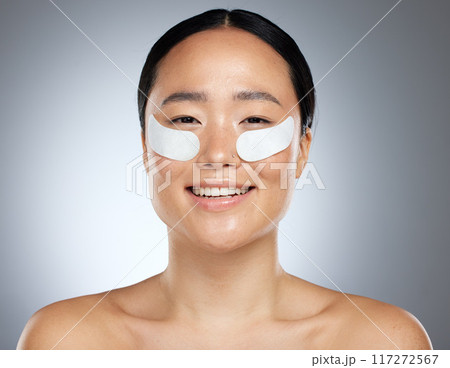 Beauty, asian and portrait of woman with patch for eye collagen skincare with happy smile. Satisfied girl model with face cosmetic treatment for skin anti aging with grey studio mockup. 117272567