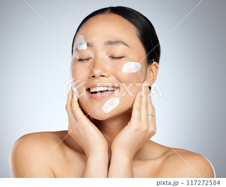 Beauty, skincare and facial product with woman and cream on face for wellness, spa and clean. Sunscreen, cosmetics and health with asian girl for luxury, salon and model lifestyle in gray background 117272584