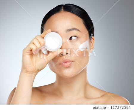 Face, beauty and skincare with a model asian woman in studio on a gray background to promote a product. Wellness, luxury and facial with an attractive young woman posing for cosmetics or health 117272594