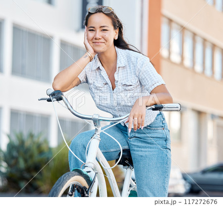 Bike, travel and city with a woman tourist riding her bicycle in a town for sightseeing or commuting. Cycling, carbon footprint and traveling with a young female enjoying tourism and adventure 117272676