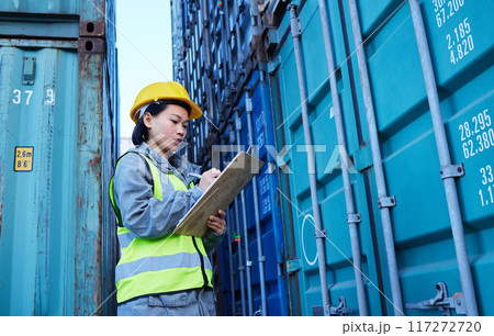 Shipping, cargo and stock container with woman reading checklist for ecommerce delivery logistics at warehouse. Supply chain, distribution and industrial management by asian manager at a factory 117272720