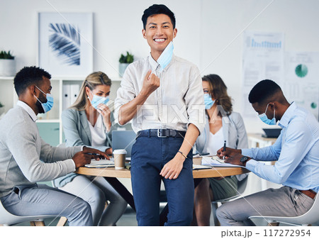 Meeting, partnership or collaboration by business people during covid in an office planning. Portrait of an Asian male corporate employee happy to remove a coronavirus face mask at end of a pandemic Meeting, partnership or collaboration by business people during covid in an office planning. Portrait of an Asian male corporate employee happy to remove a coronavirus face mask at end of a pandemic 117272954