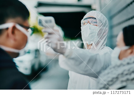 Travel restrictions, airport or border testing patient temperature outside with a thermometer. Medical safety officer doing a covid check on a man at the entrance to prevent the spread of the virus. 117273171