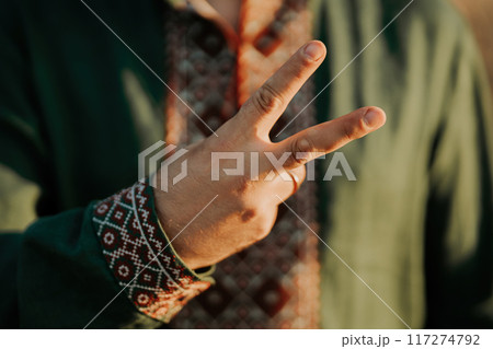 Ukrainian man in vyshyvanka shirt showing hand With Peace Sign,V Victory Gesture Ukrainian man in vyshyvanka shirt showing hand With Peace Sign,V Victory Gesture 117274792