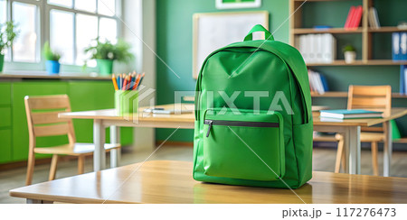 A green school backpack sits on a wooden desk A green school backpack sits on a wooden desk 117276473