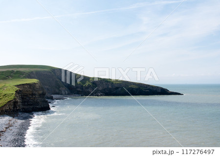 砂利が続く海岸線と海水の浸食で断崖絶壁になった入江　南ウェールズの郊外にて 117276497