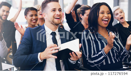 This was the best seminar yet. Cropped shot of a handsome young businessman sitting with his colleagues and holding a notebook while in the office. 117276594