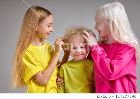 two girls touching their friends fluffy, wavy, curly hair 117277540