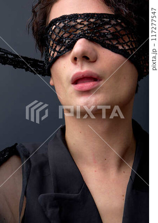 Passionate male wearing semi-open eye mask posing, stylish, dressed in black jacket 117277547