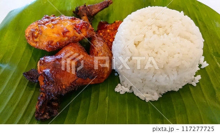 A Meal With Grilled Chicken Wings And Plain Rice On Banana Leaf. 117277725