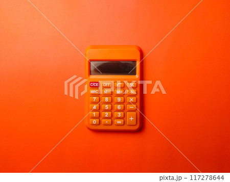 Top view orange calculator on a orange background. Top view orange calculator on a orange background. 117278644