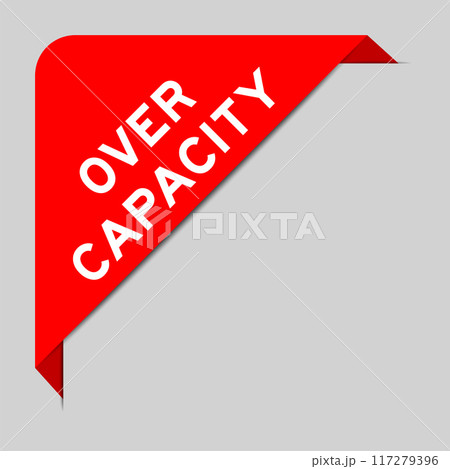Red color of corner label banner with word over capacity on gray background 117279396