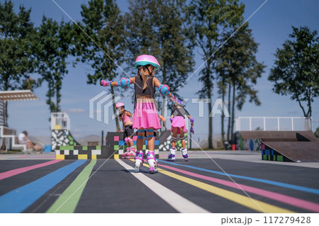 Children roller skating at the Rollerdrome on a sunny summer day Children roller skating at the Rollerdrome on a sunny summer day 117279428