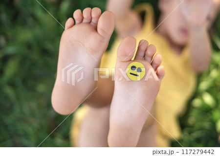 A sad little smile face on a child's foot. 117279442