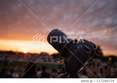 夕暮れでカメラを構える 夕暮れでカメラを構える 117280119