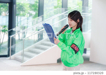 笑顔で案内をするイベントスタッフ 117280320