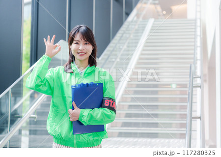 笑顔で案内をするイベントスタッフ 笑顔で案内をするイベントスタッフ 117280325